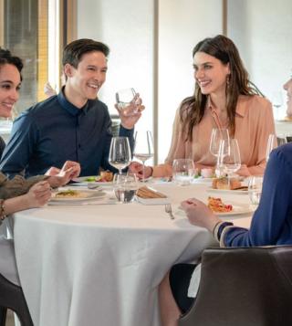 Amici a cena che bevono Acqua Panna