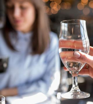 Ragazza che degusta acqua in un bicchiere