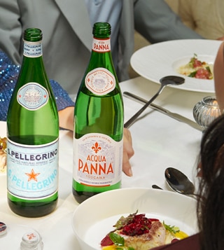 Bicchieri e bottiglie di acqua su tavola apparecchiata